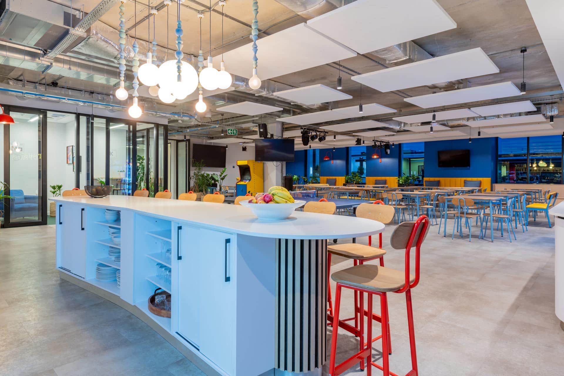 Office bar counter with tables and chairs and hanging light pendants