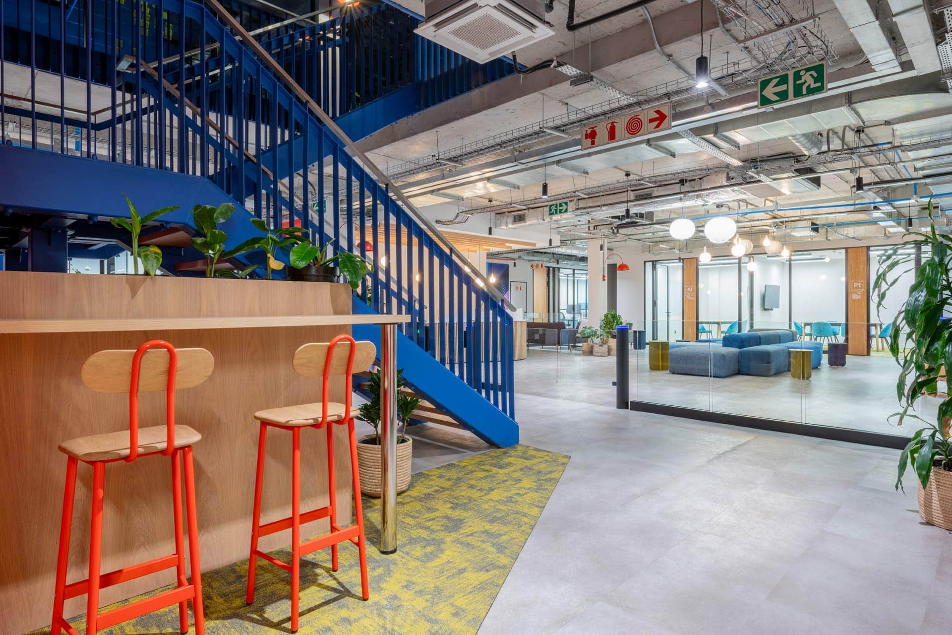 Bright blue staircase with red chairs in foreground