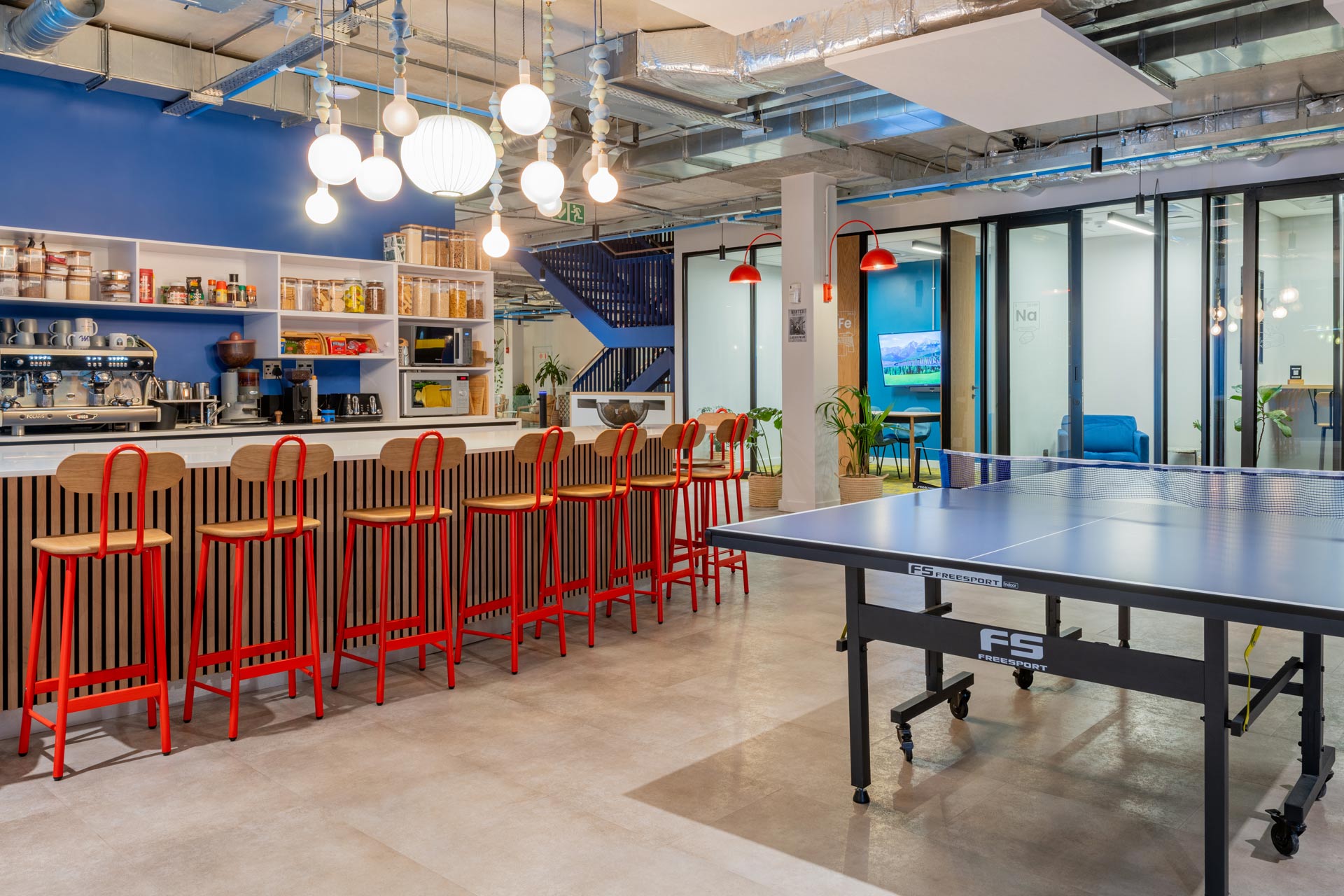 Colourful high chairs at office bar and ping pong table