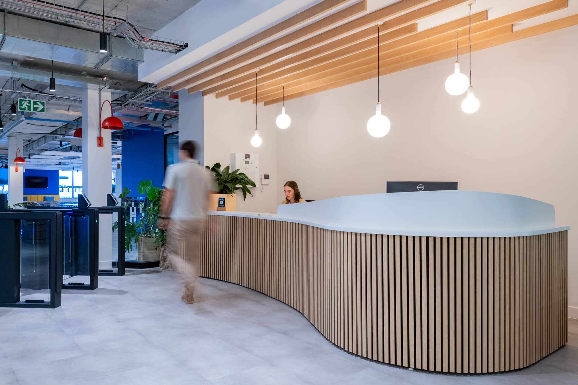 Reception desk with wooden slat detailing and people