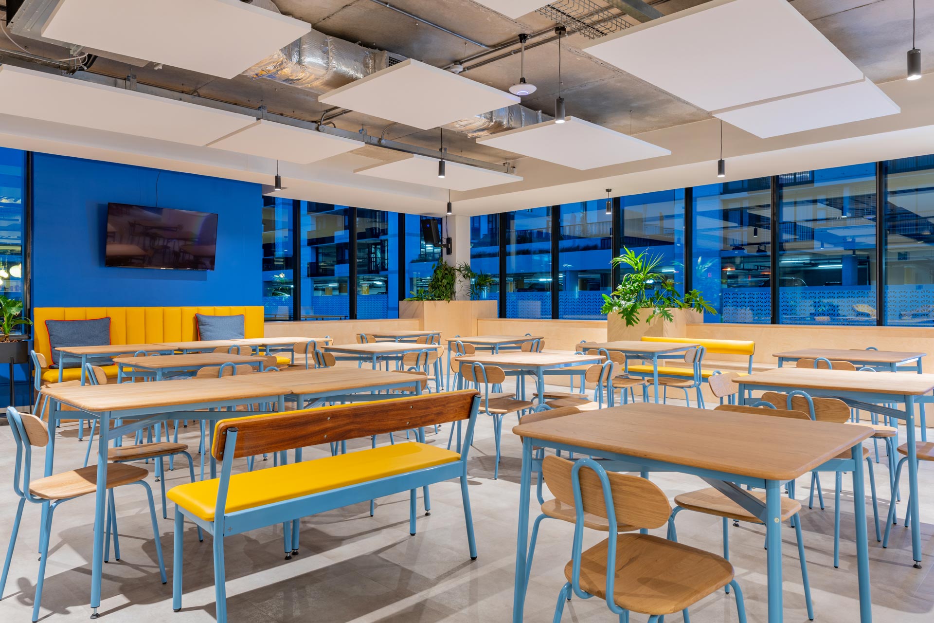 Cafeteria tables with wood and metal detail and pops of playful colour