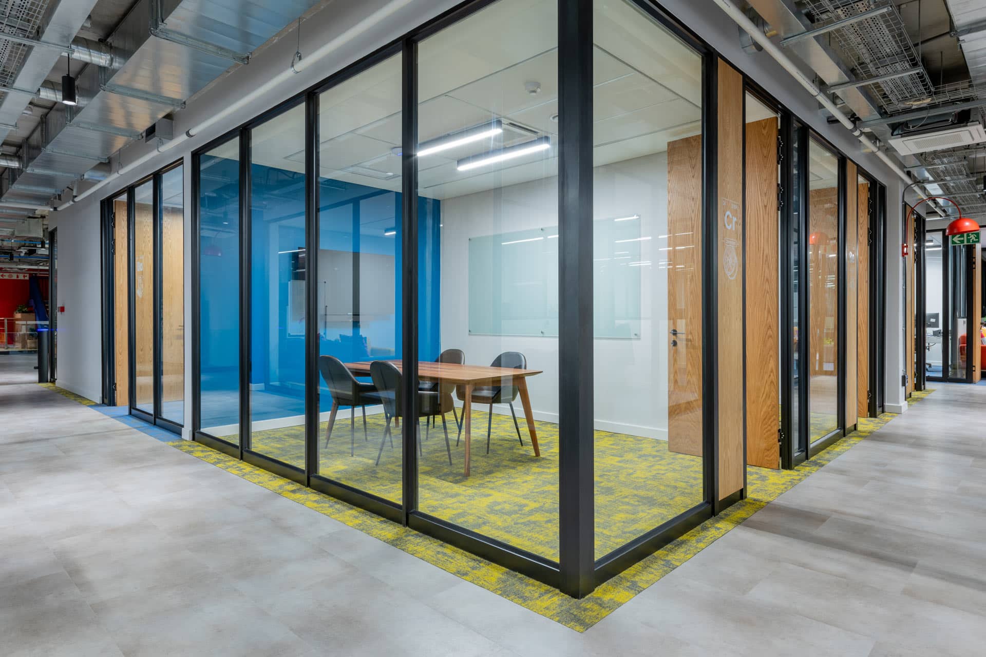 Glass walled corner meeting room with blue wall