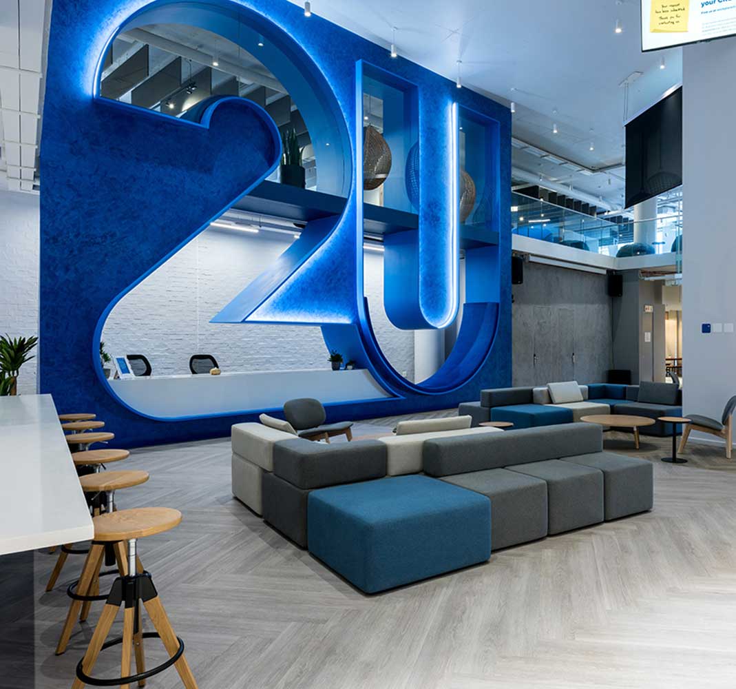 A commercial office reception area with branded signage built by trend group in a turnkey build