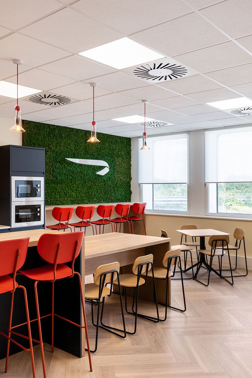BA Euroflyer London office canteen design and build with communal tables, wooden chairs and red bar stools