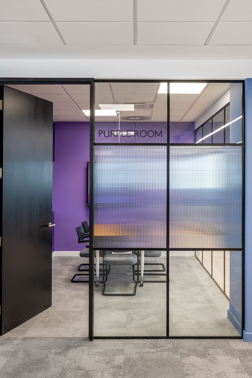Glass entrance to BA Euroflyer purple meeting room with acoustic privacy glazing
