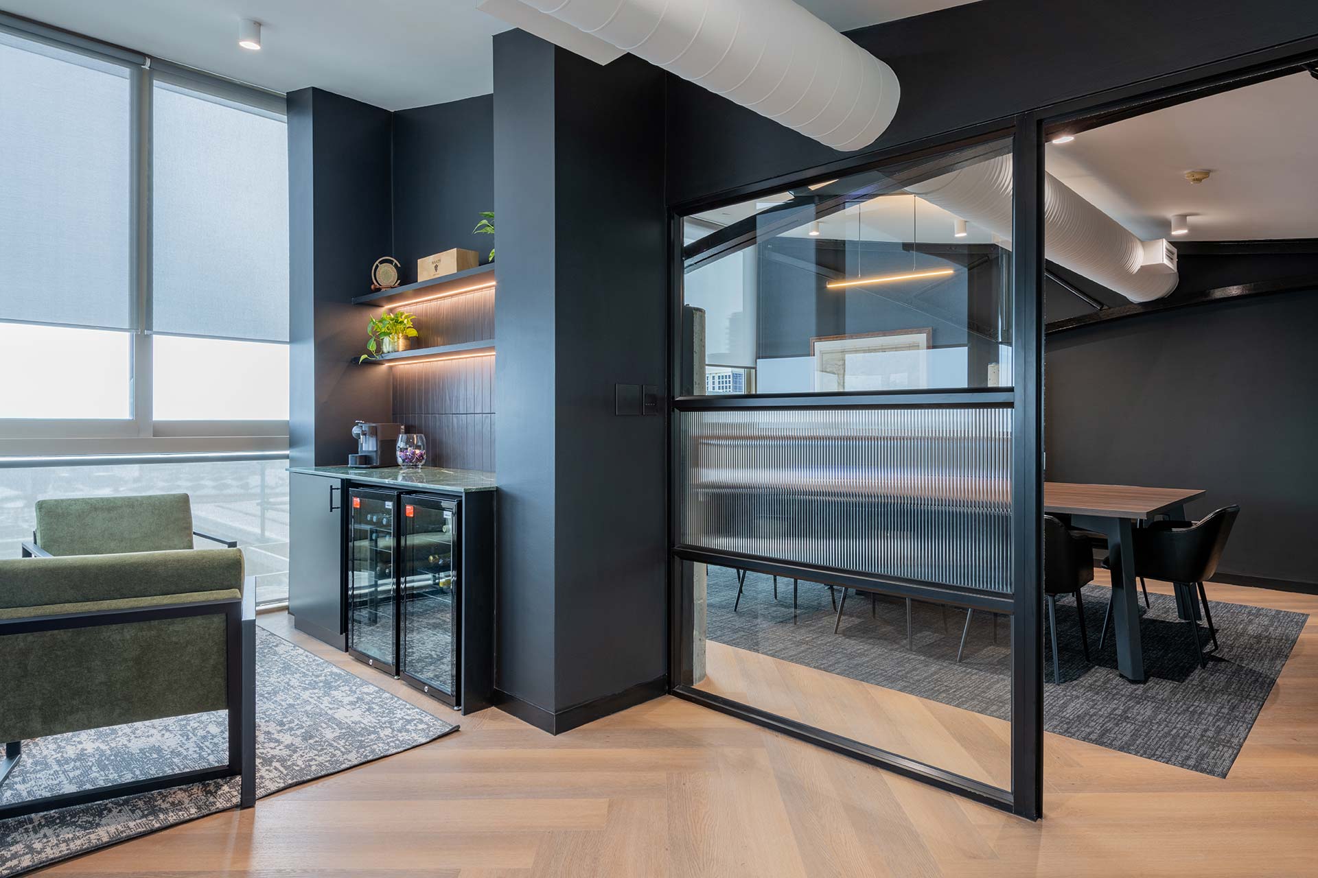 Lionhead Capital office design consisting of mezzanine lounge bar area with green upholstered seating and contemporary office furniture
