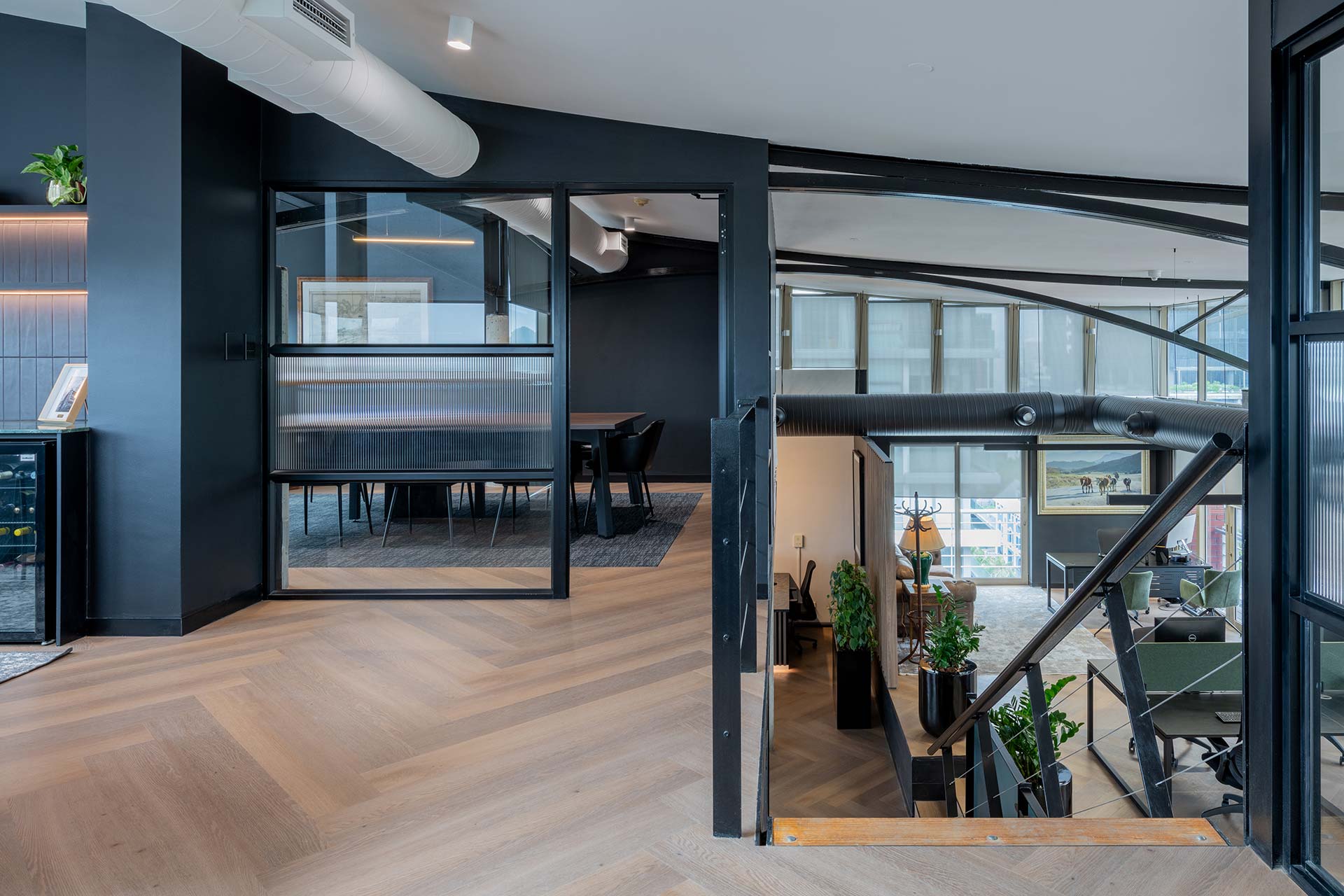 Modern open plan Lionhead Capital office lounge with glass partitions and contemporary workplace furniture and excellent commercial construction