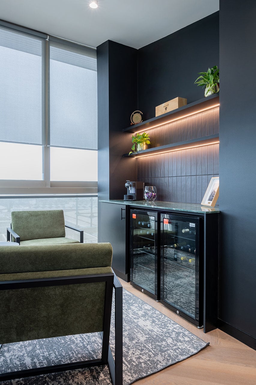 Lionhead Capital offices mezzanine lounge seating with upholstered armchairs and integrated office shelving and bar design